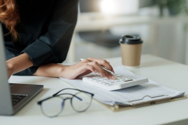 Ödeme planı tablosunu inceleyen bir kişi ve dijital hesaplama ekranı